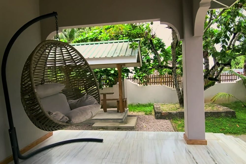 The hanging egg chair on the veranda of the Avocado studio at Alibel Beach Villa