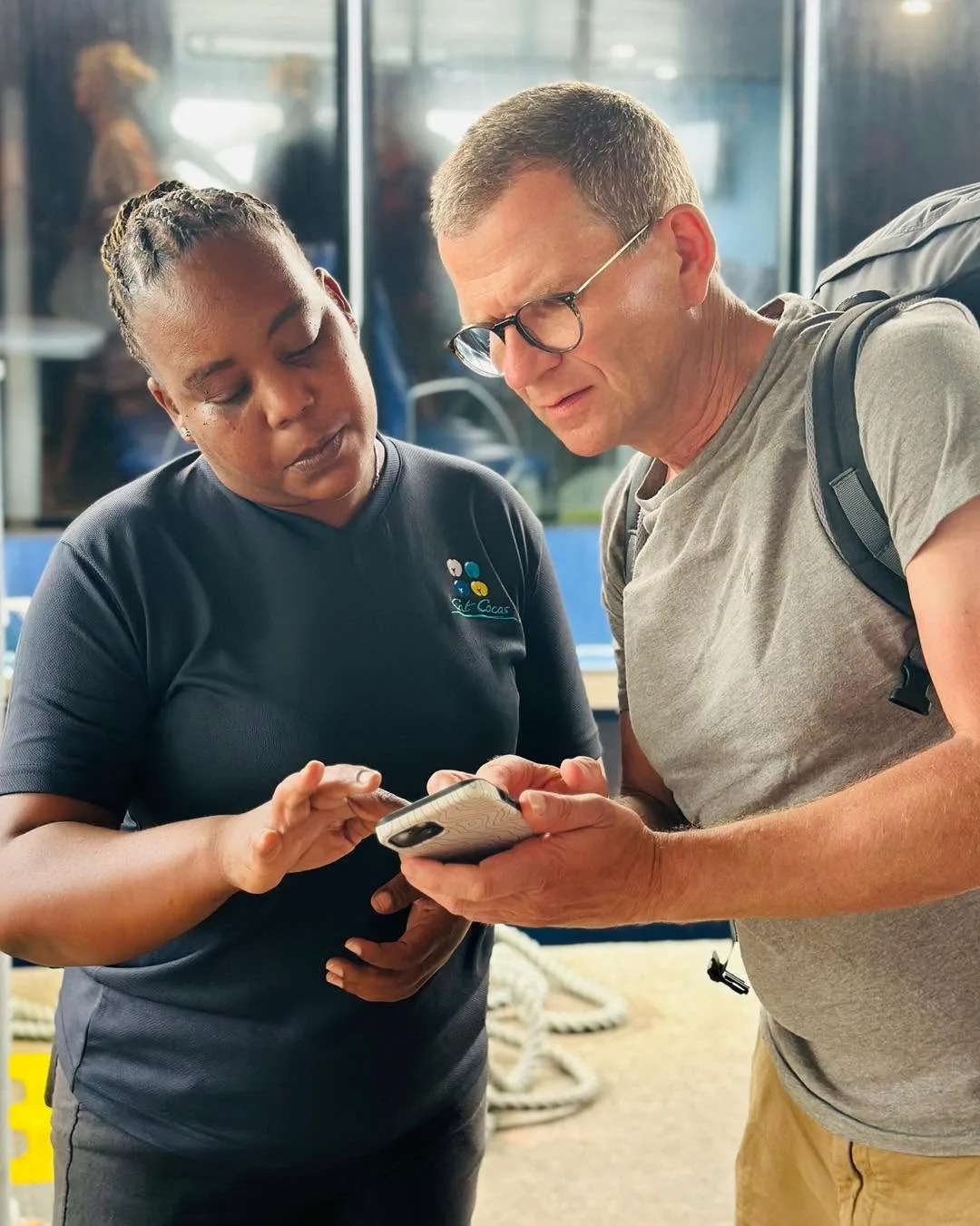 A crew member checking a passenger in on a tablet at the ferry terminal