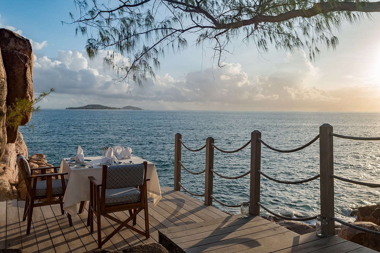 The same terrace above the water on Praslin, laid for lunch in daylight.
