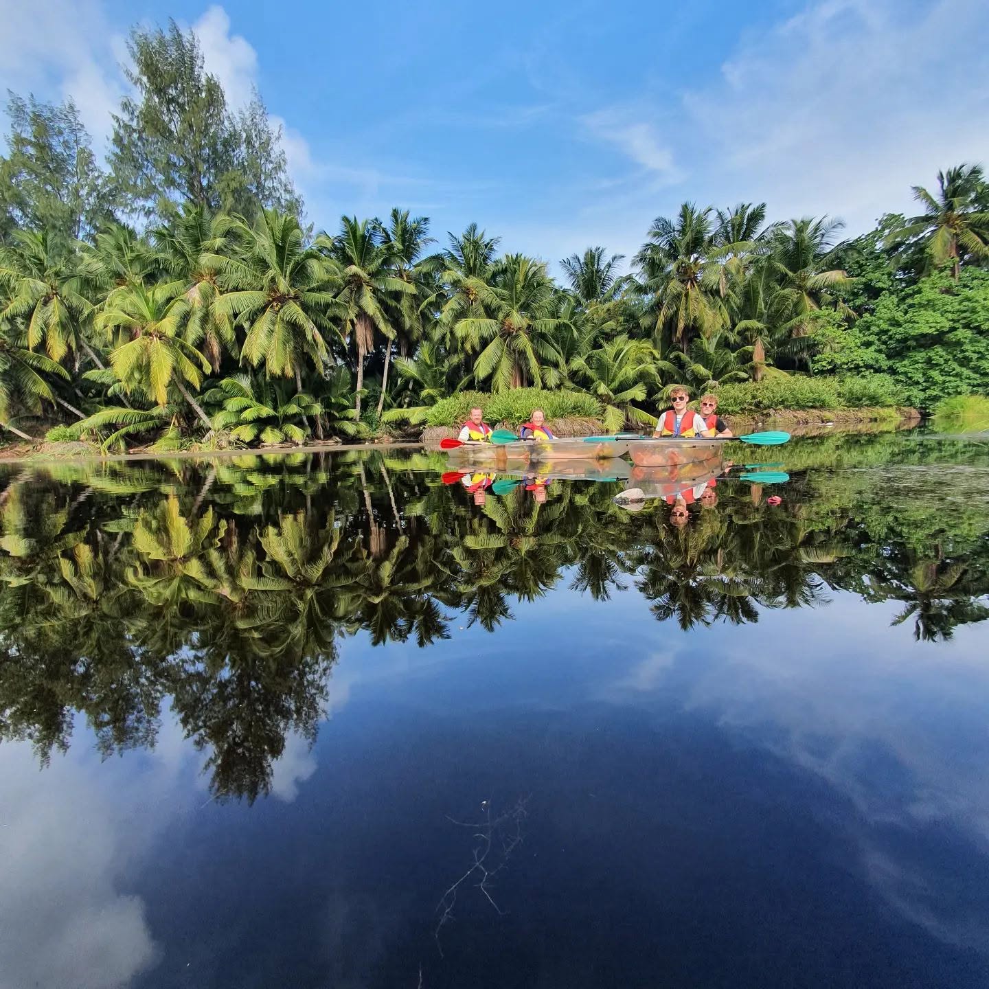 Small group kayaking on the mirror-still Grand Police wetlands, Mahé