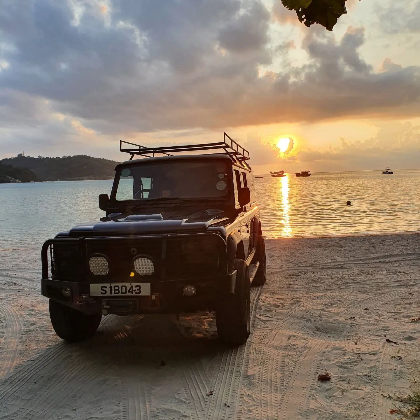 Defender parked at the beach at sunset, Mahé
