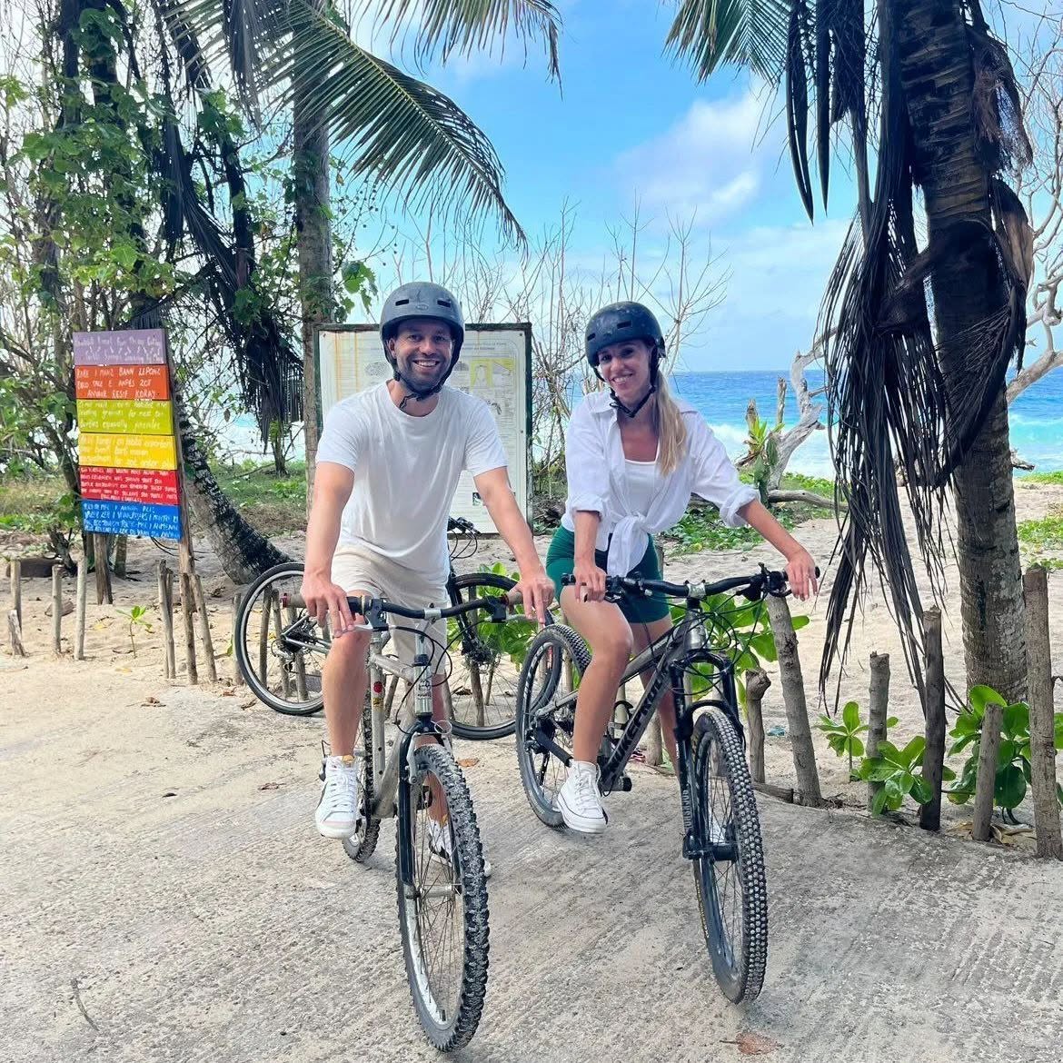 Couple with electric bikes on a coastal road, Mahé