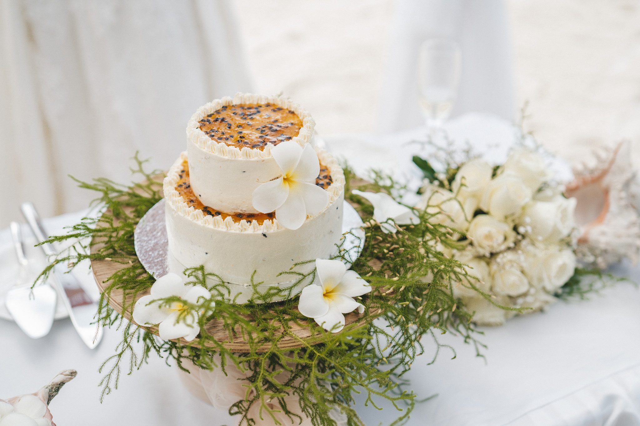 The cake dressed with frangipani and greenery on the table