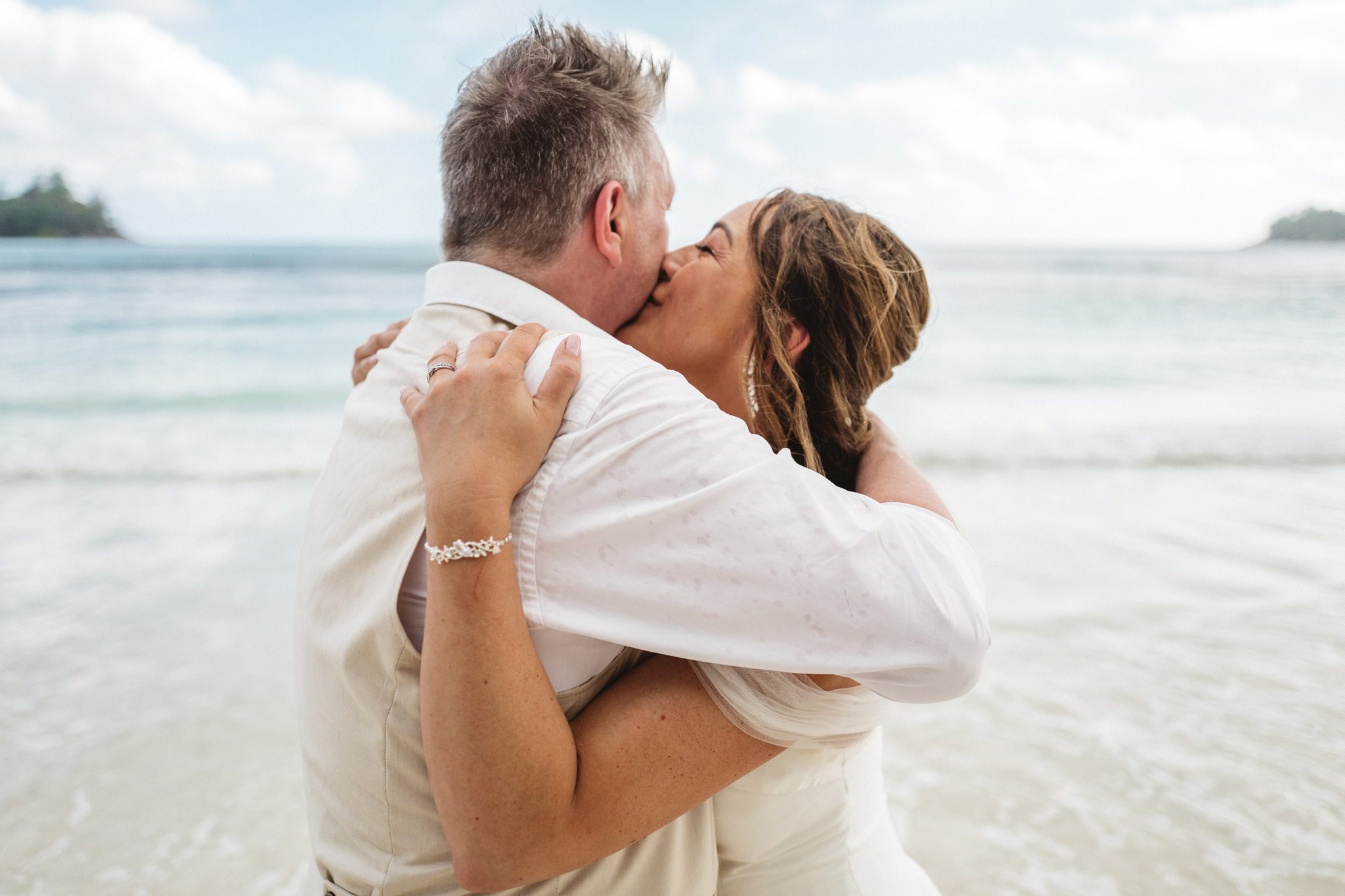 A couple in the shallows after the ceremony.