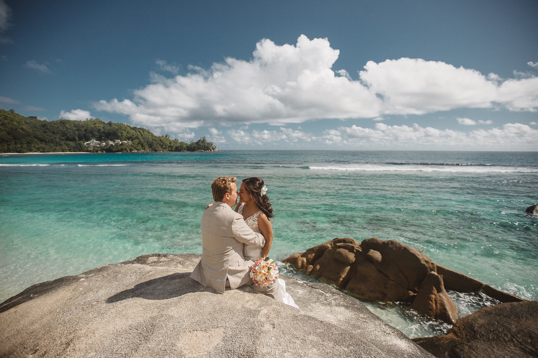 A couple on the granite above the reef in Seychelles.