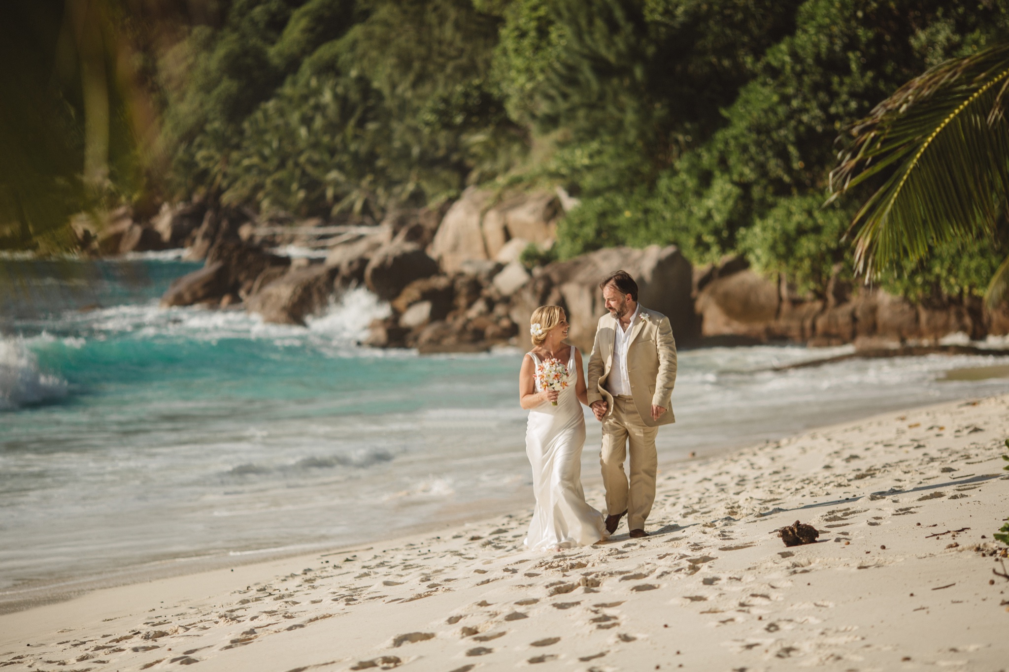 The couple walking a small cove where the surf comes in against granite
